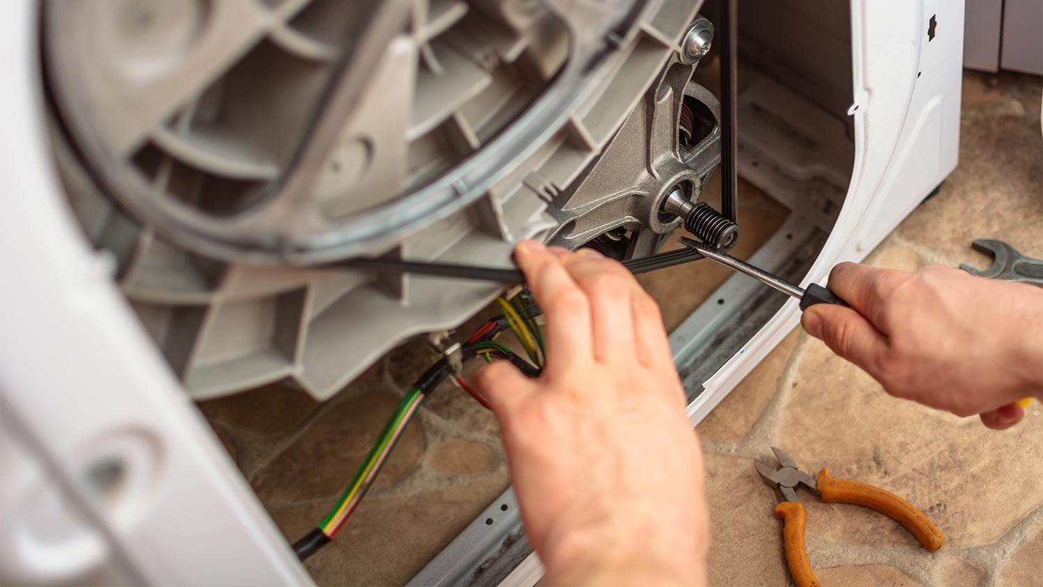 A person repairing a dryer