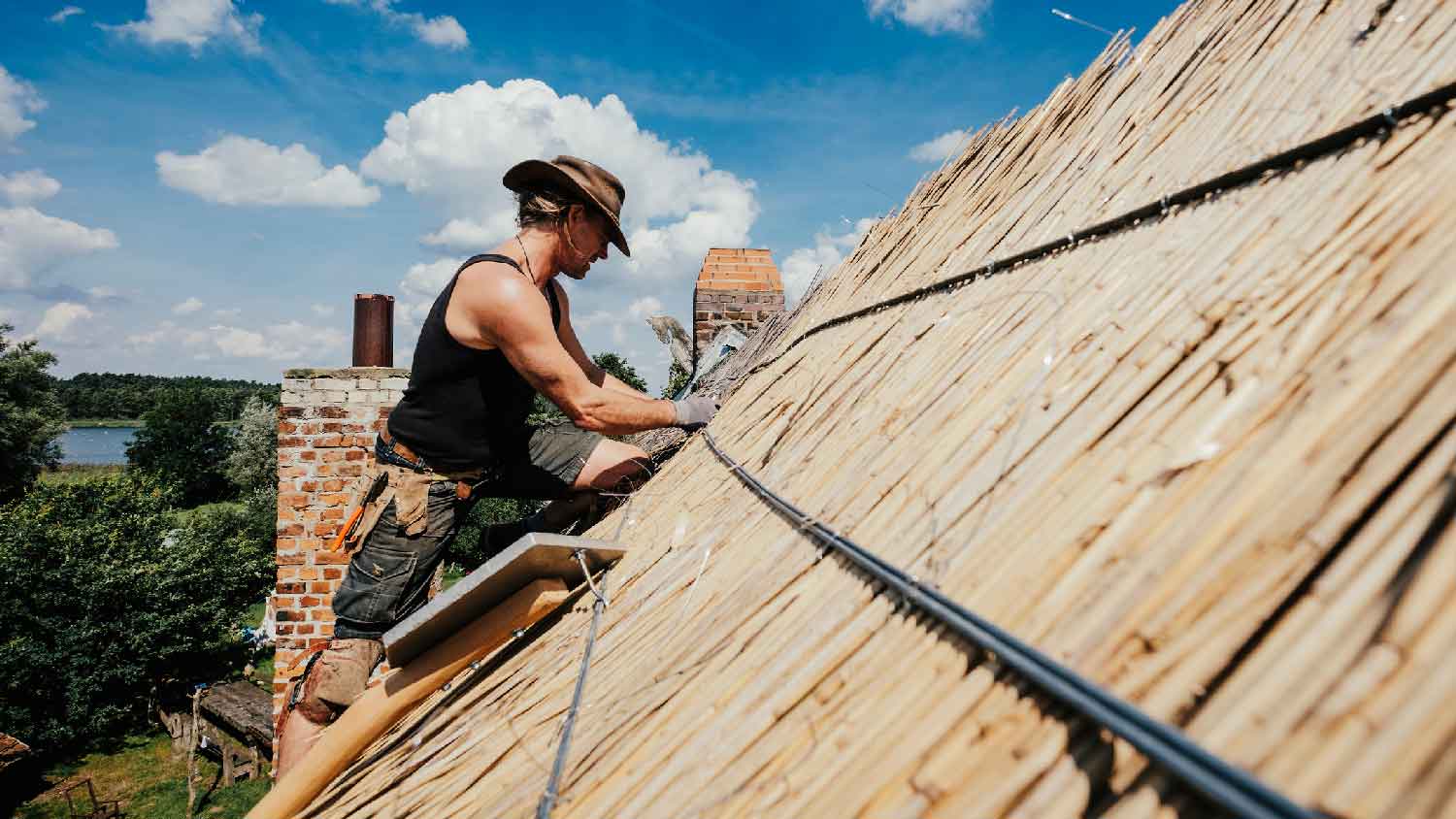 A man repairing a thatched roof