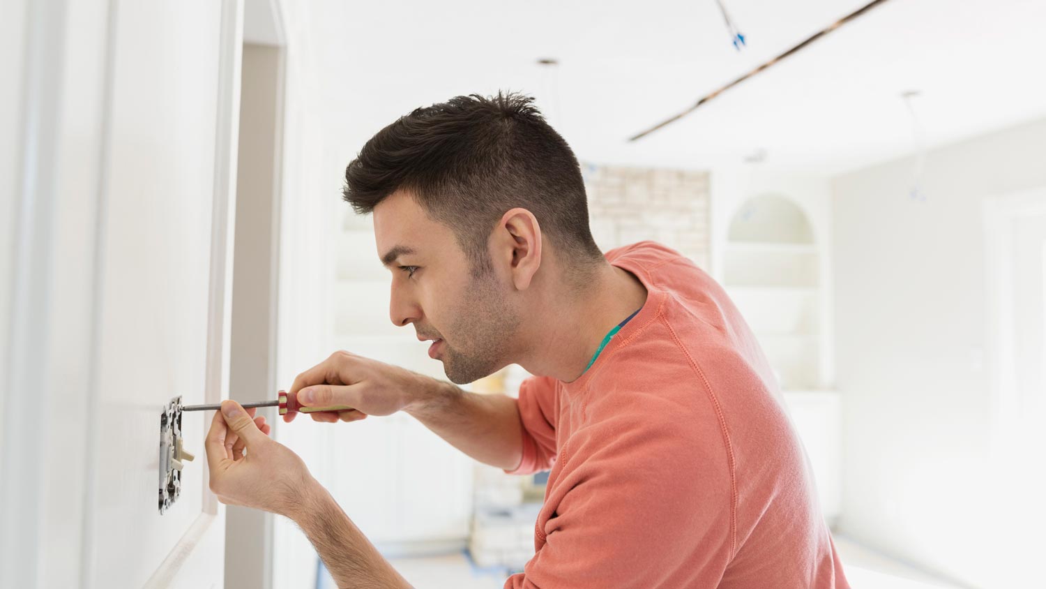 A man replacing a light switch