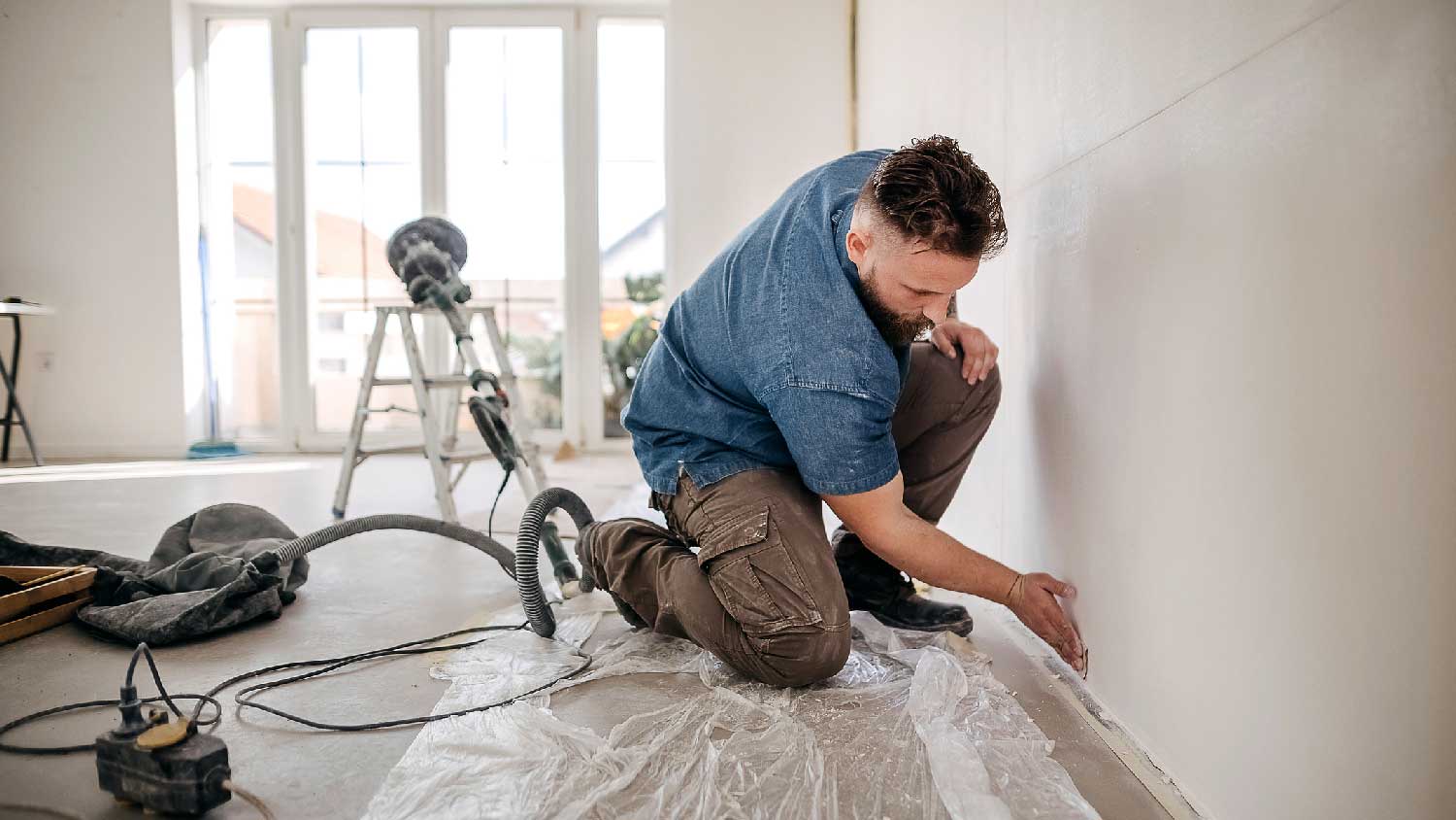 A man sanding a new drywall