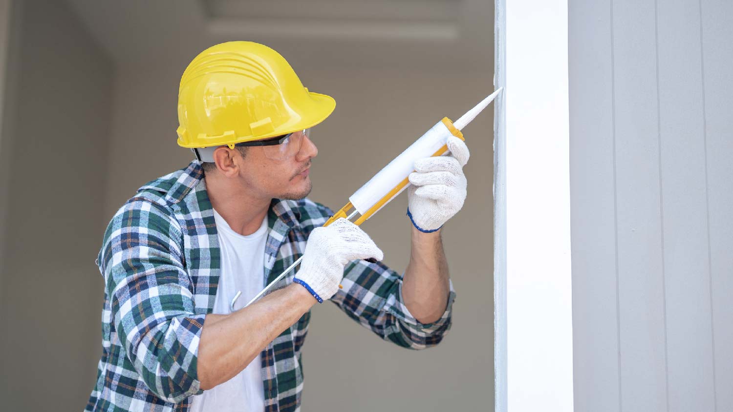 A man sealing a door jamb