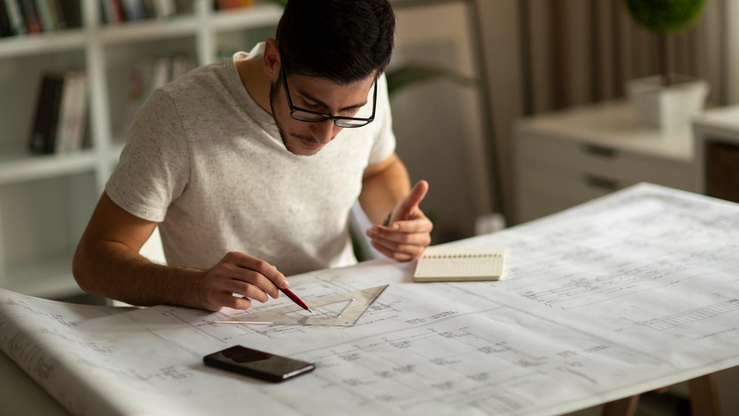 A man sketching a room on paper