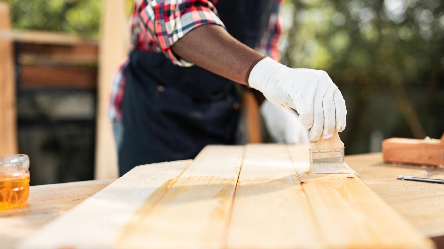 A man staining pressure treated wood