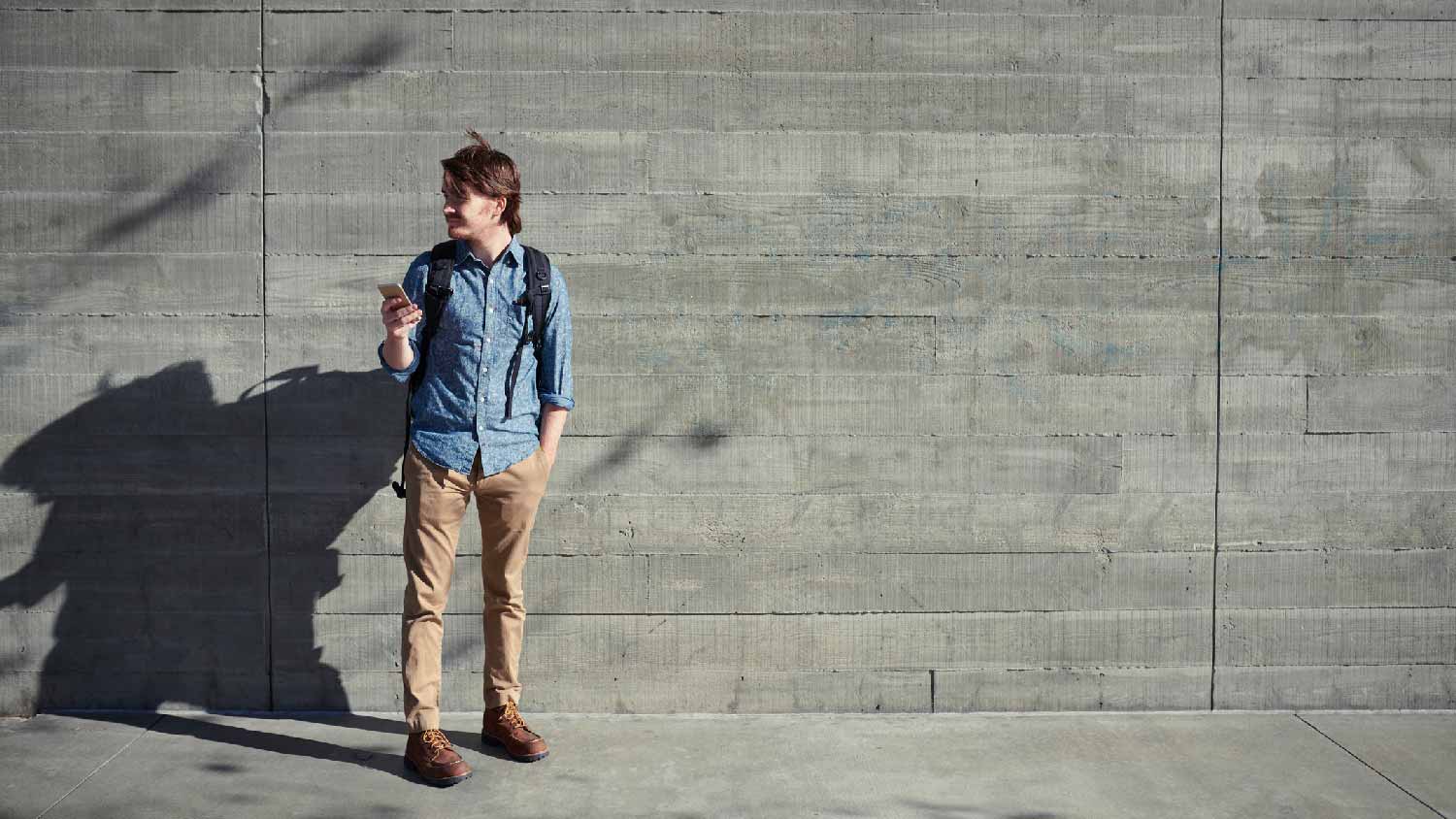 A man standing in front of a concrete wall