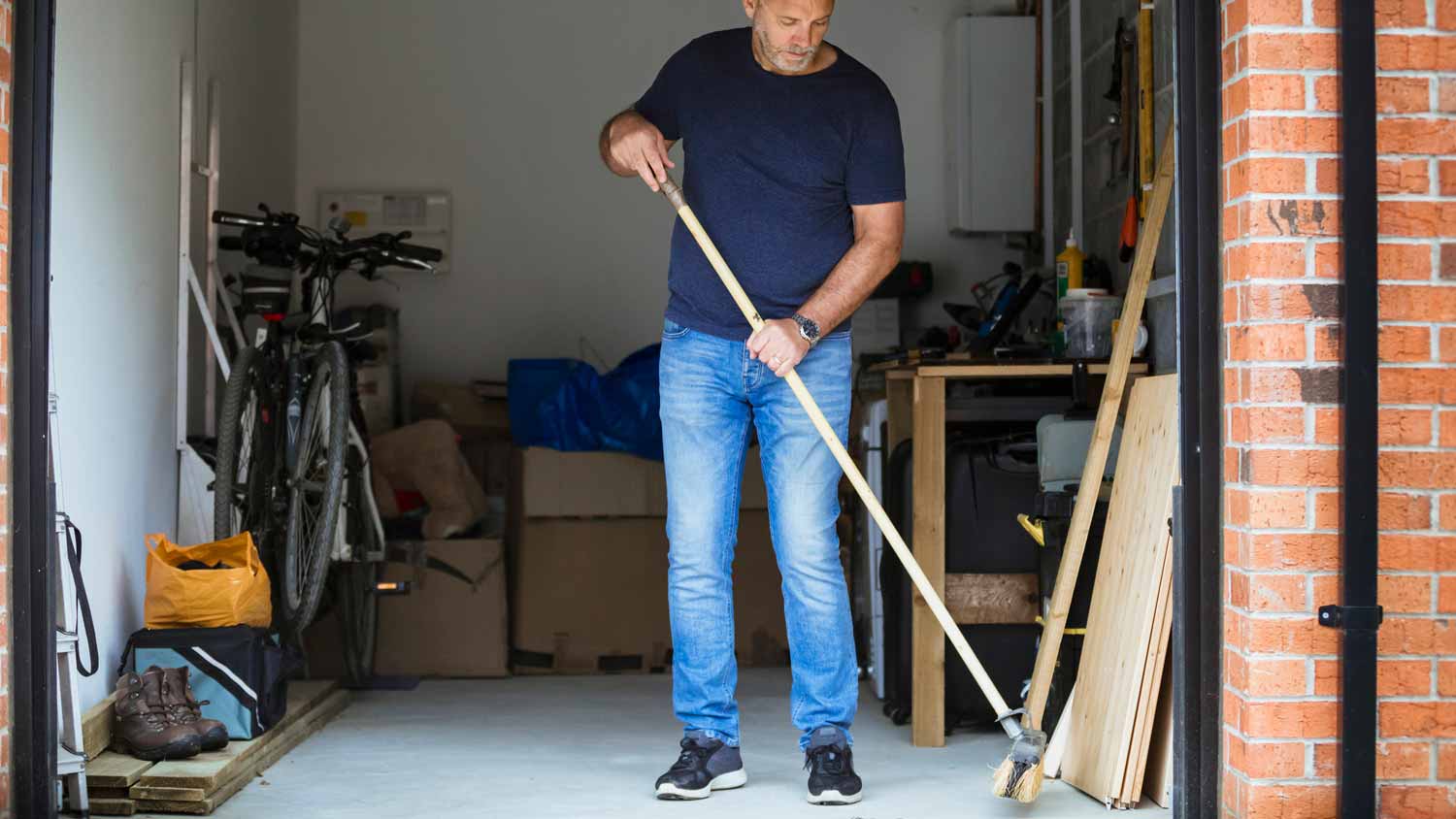 A man sweeping a small garage