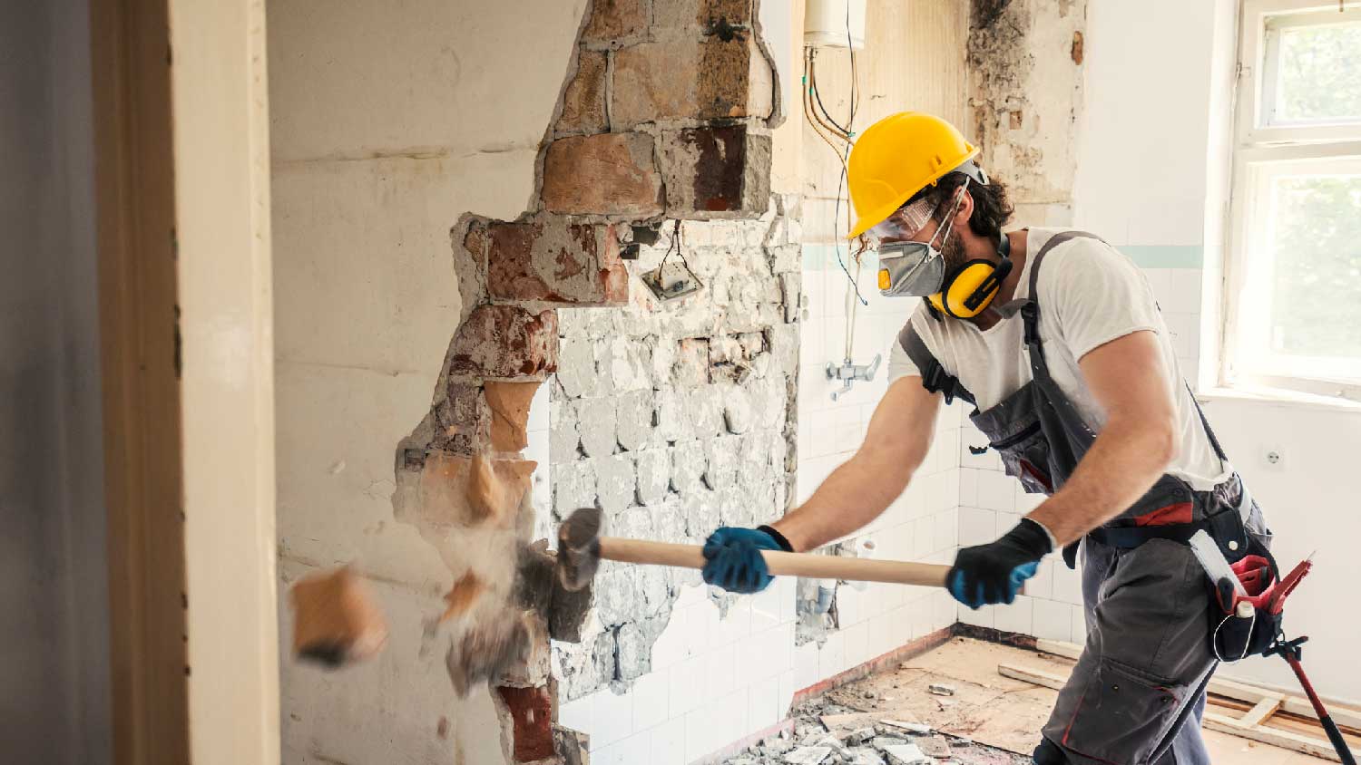 A man tearing down a wall