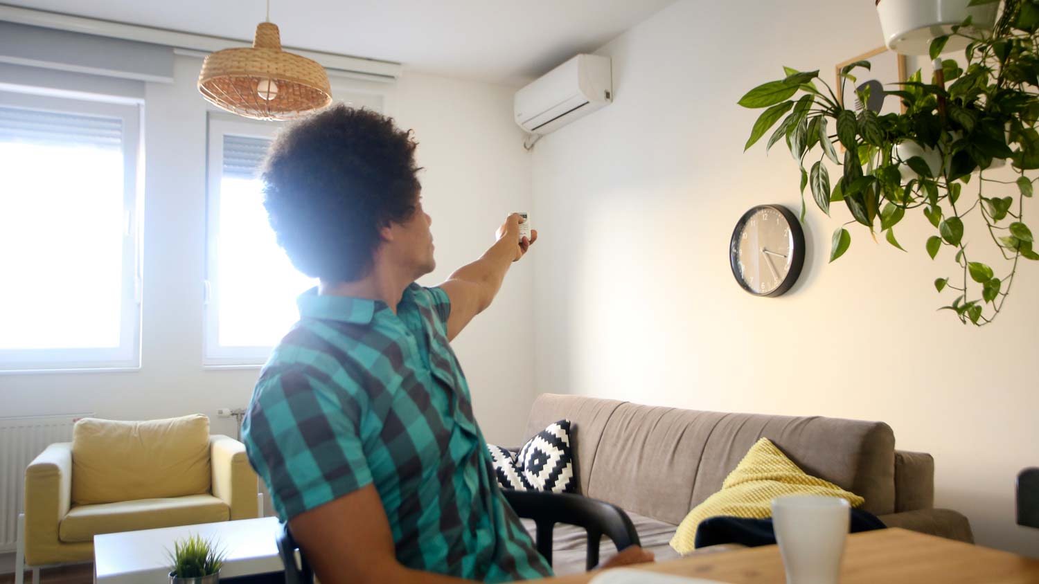 A man turning the AC on in his living room