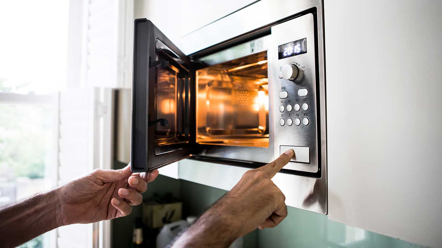 Man opening microwave door