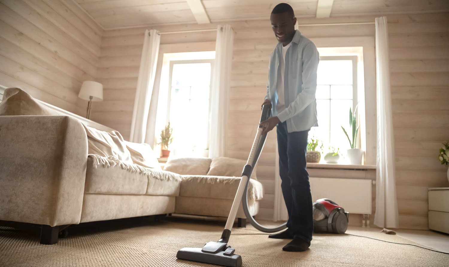 Man vacuums carpet