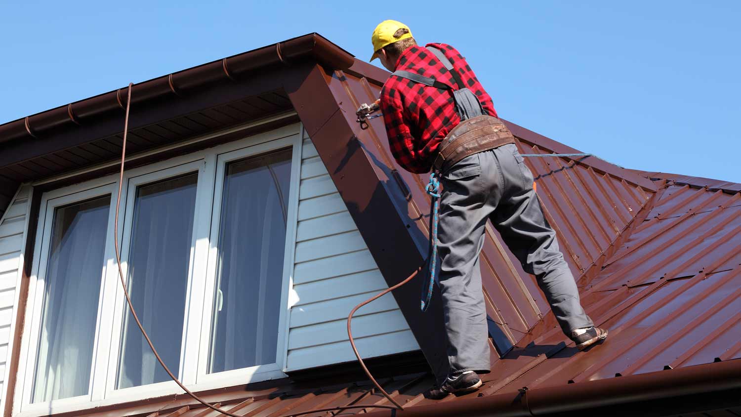 man walking on metal roof