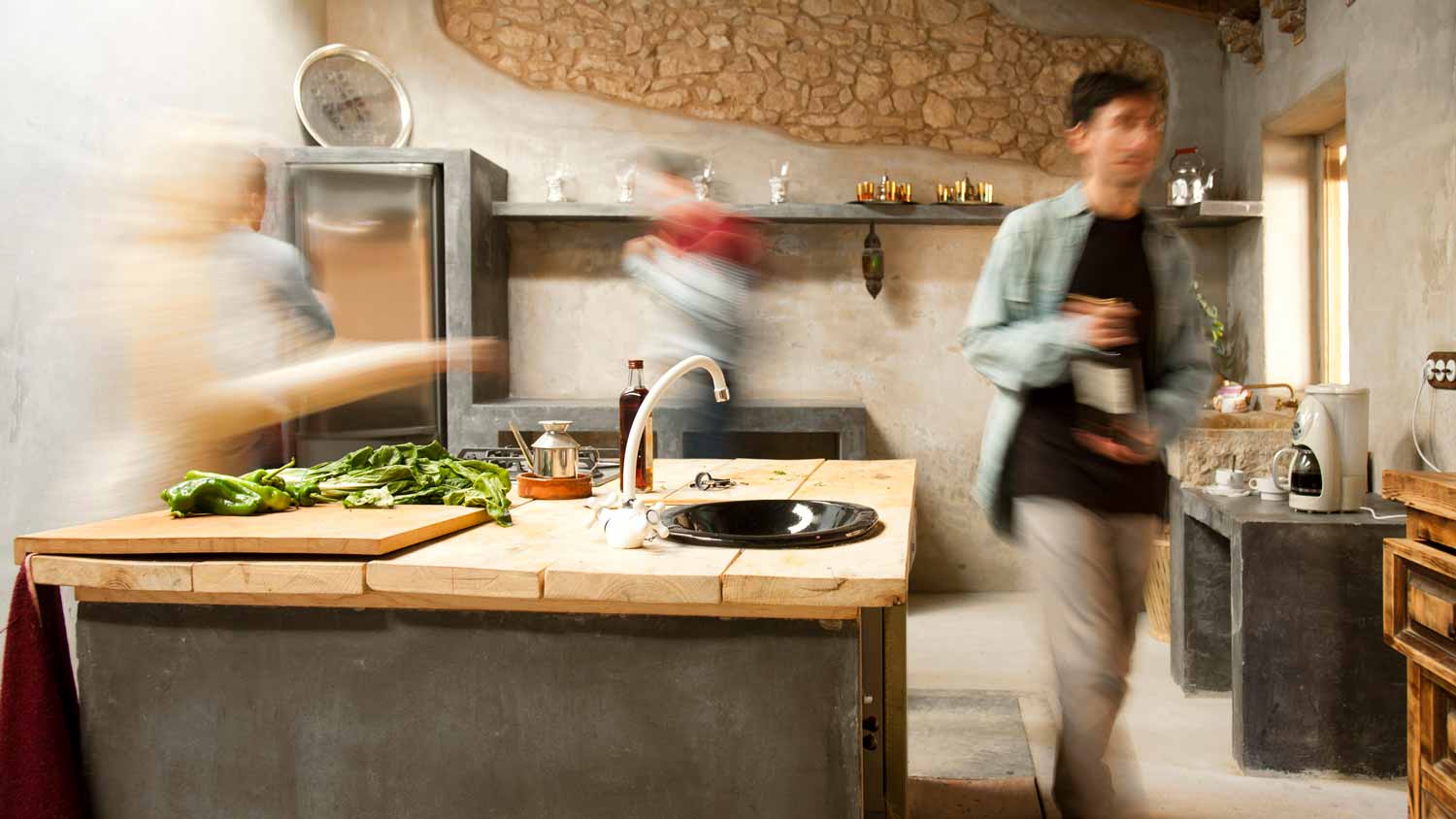 A man walking past a kitchen island