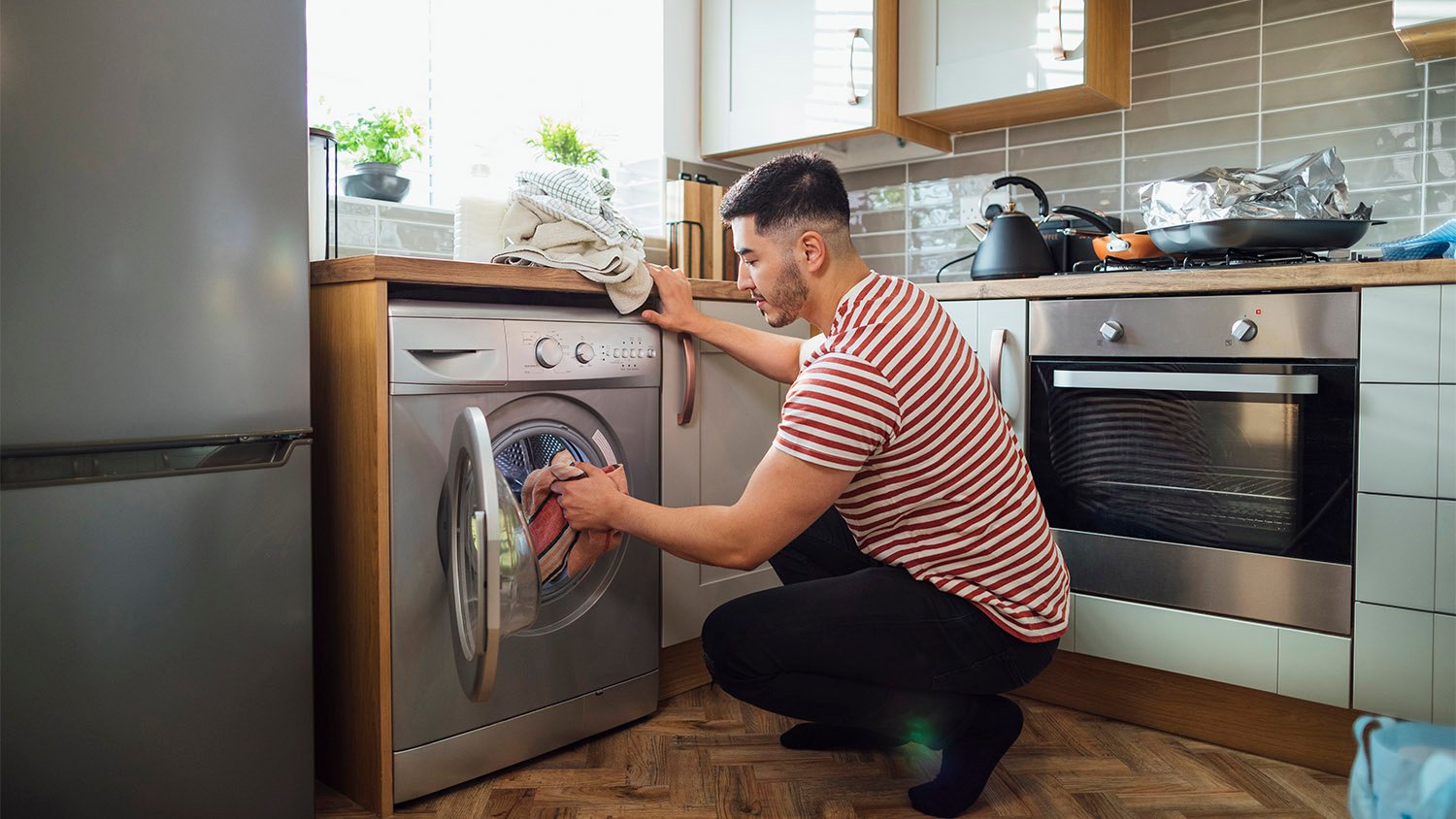 man washing clothes in kitchen