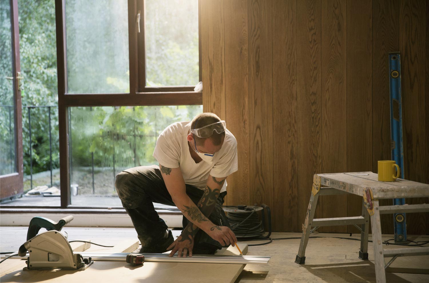 A man measuring a wood board in house