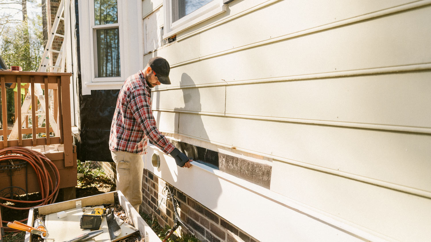 Construction worker repairing a house siding