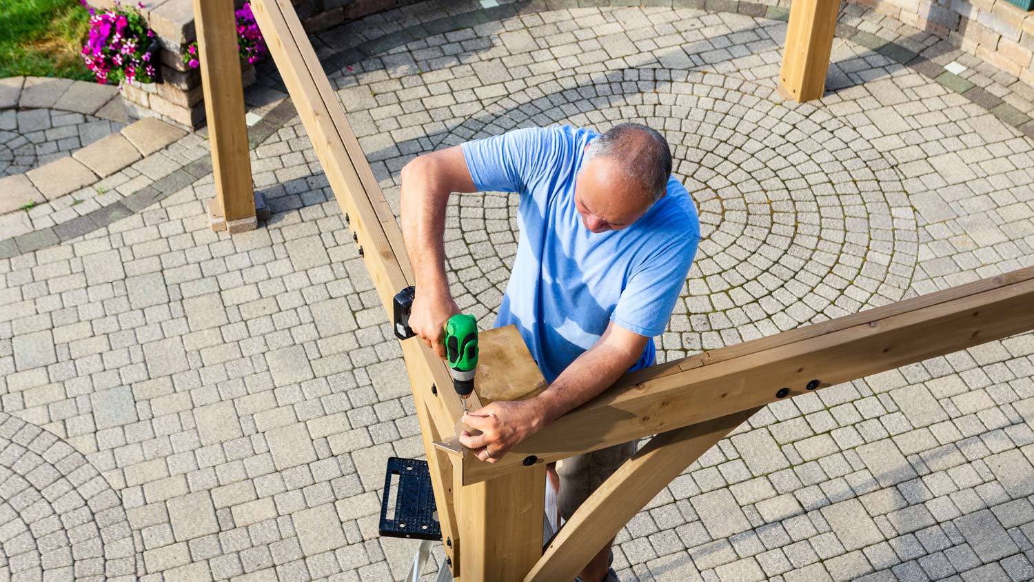 Man building wooden structure on patio