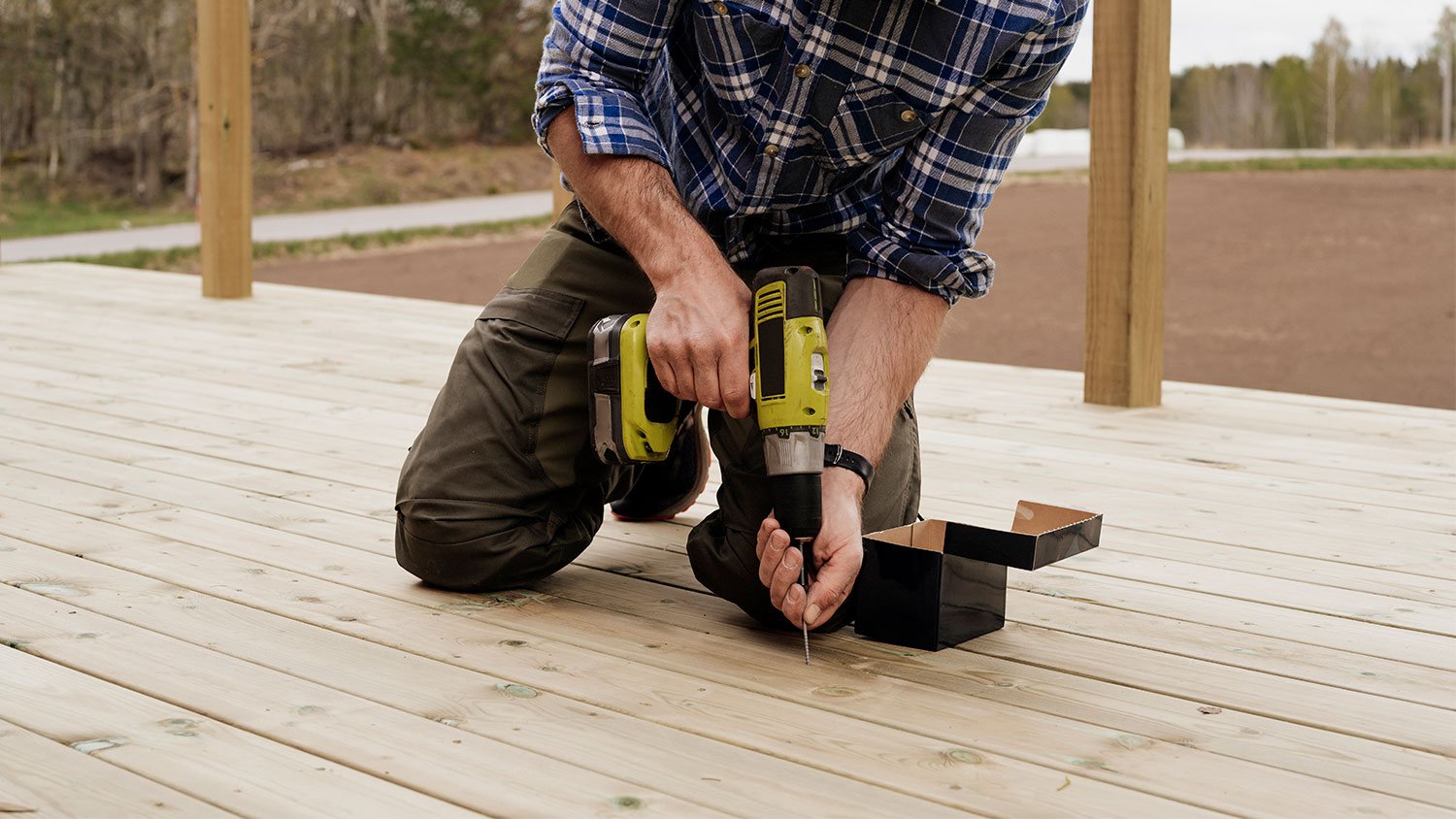 Man building a wooden patio deck outdoors in his garden