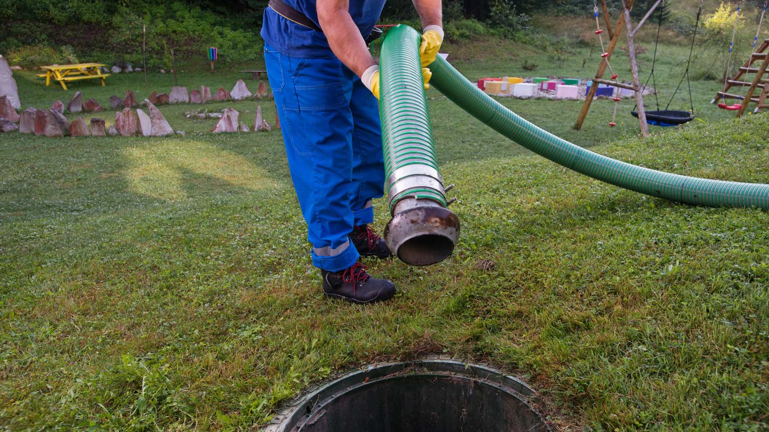 Emptying household septic tank. Cleaning and unblocking clogged drain with vacuum pipe.