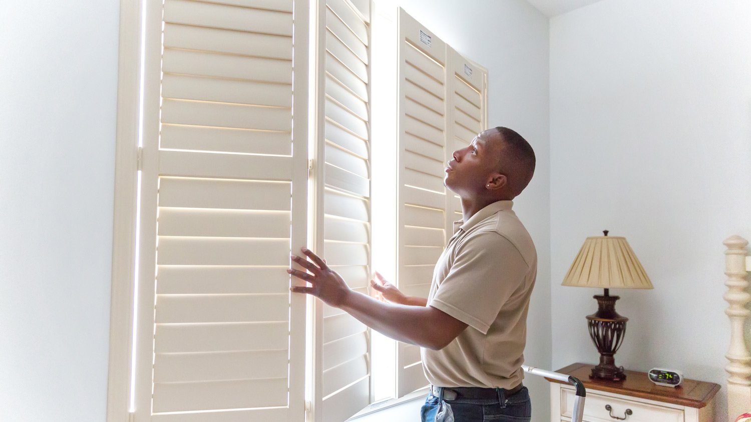 Window treatment installer installs wooden shutters