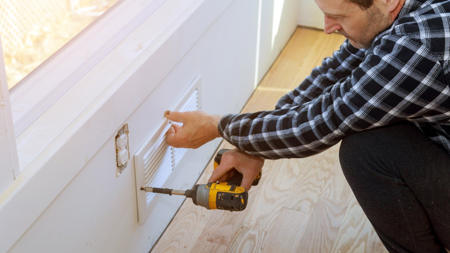 Man removing vent on air duct