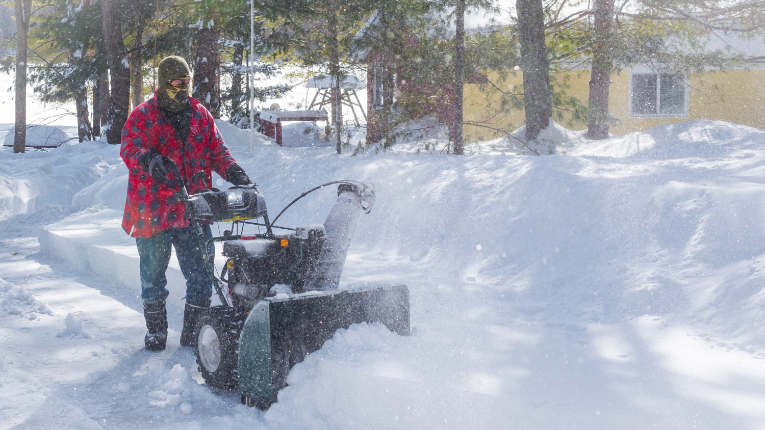 Canadian Man operates snow thrower on winter day in Canada