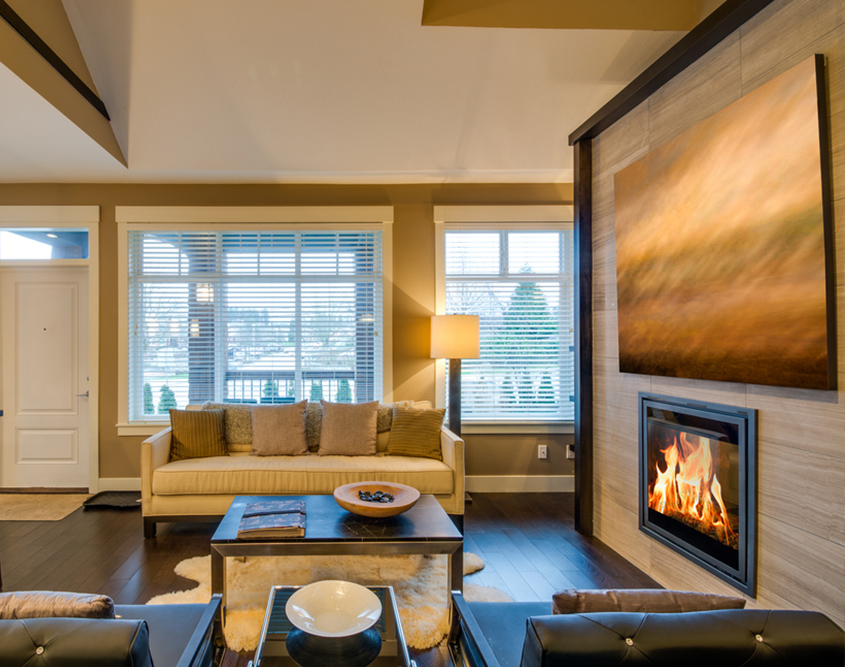 Large piece of artwork above glass fireplace in living room