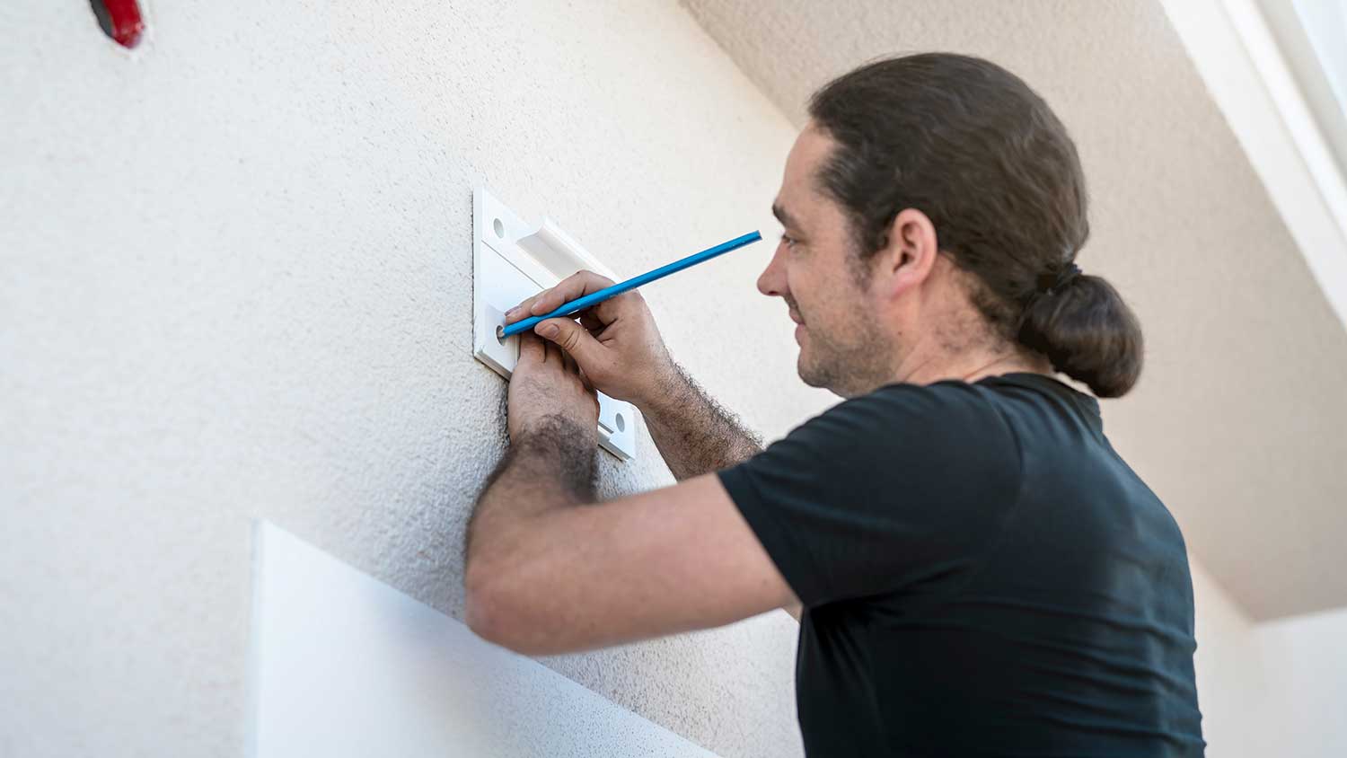 Worker marking bracket mounting location on the wall