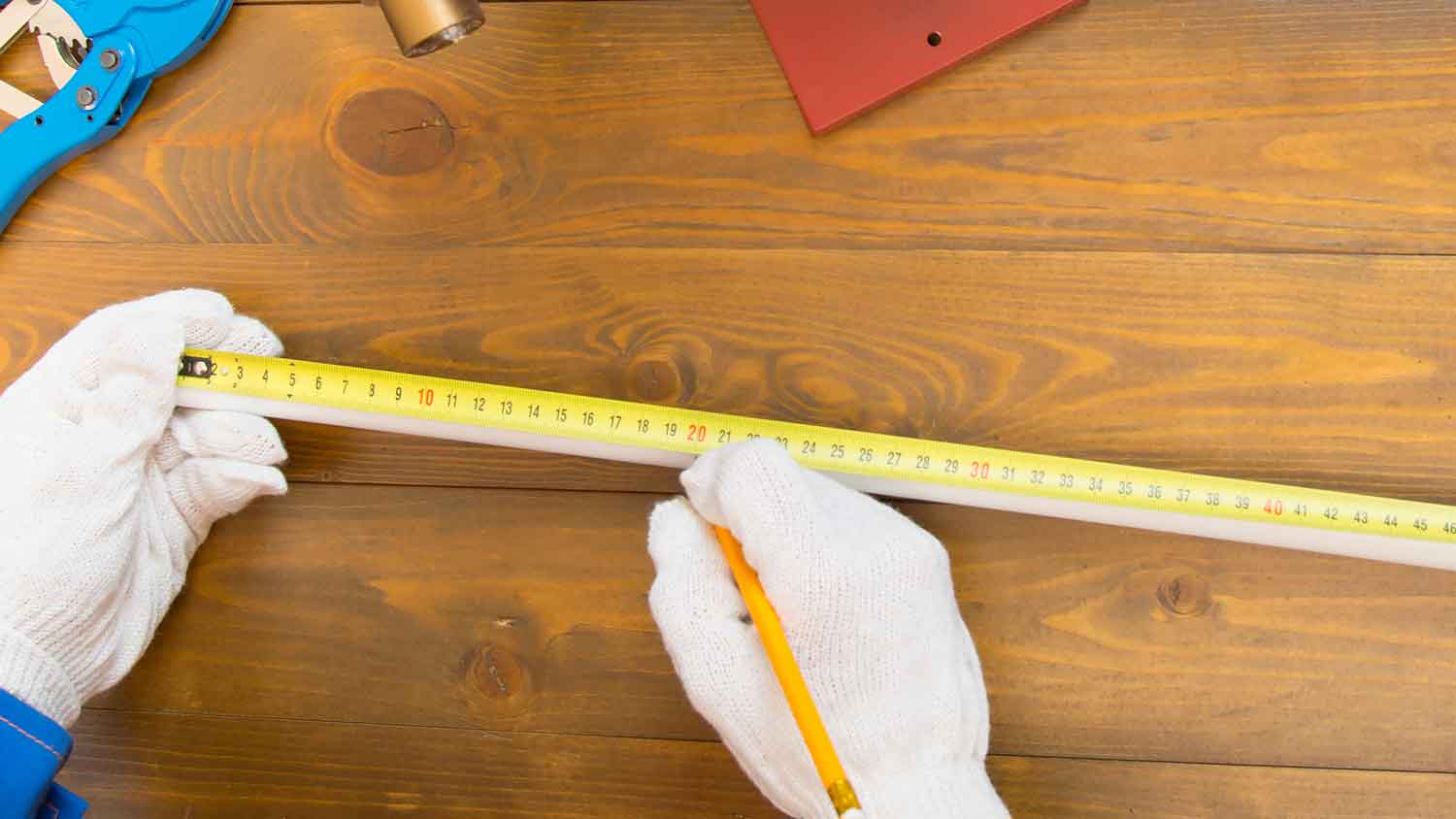 Plumber marking measurements on a pipe