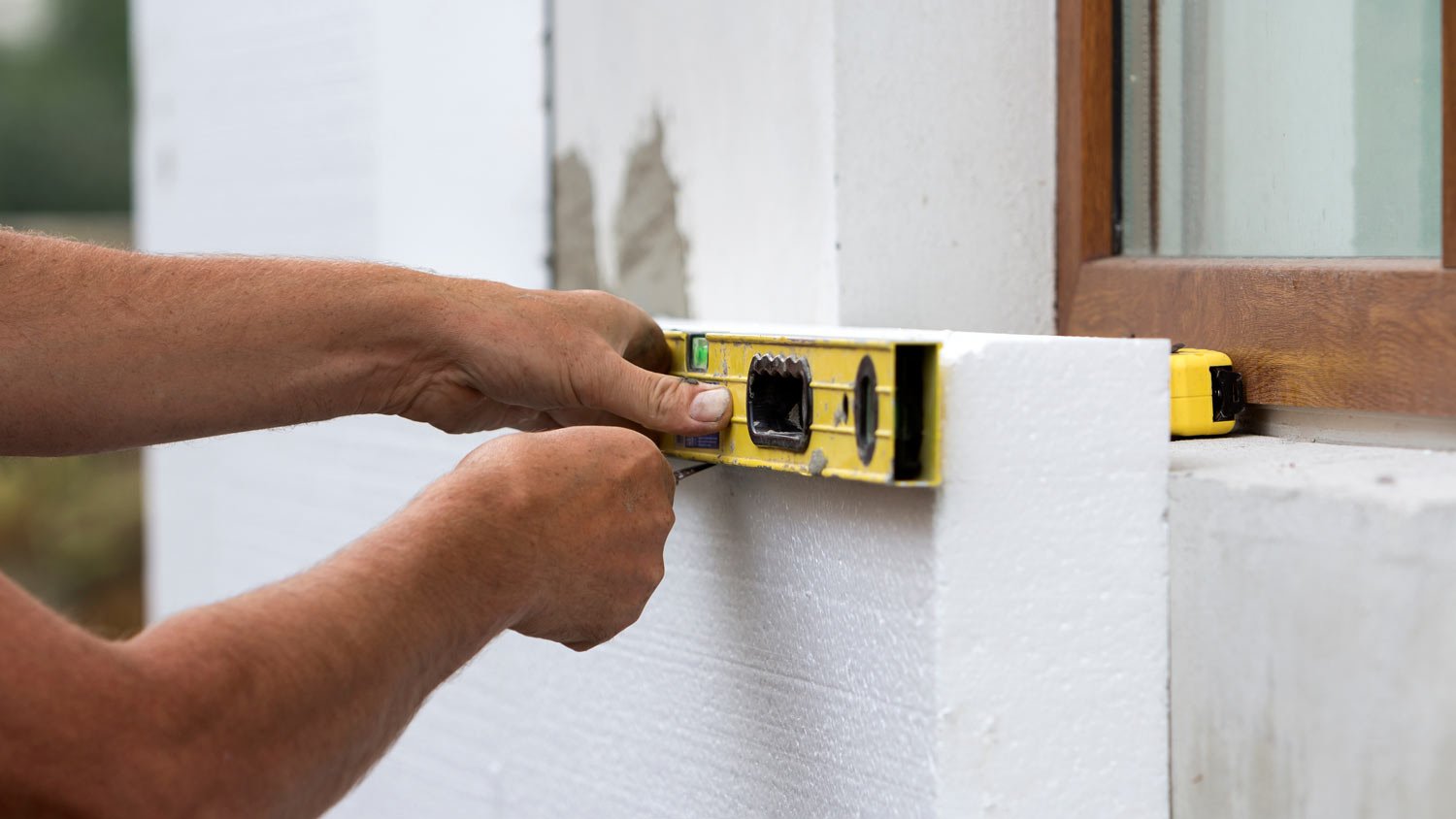 man measuring foam board