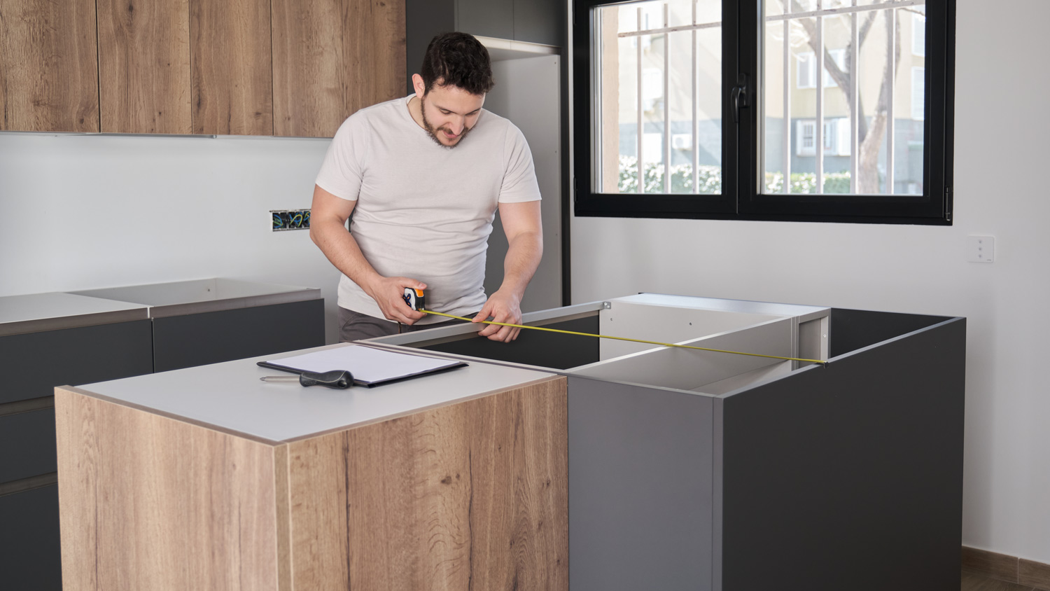 Man using measuring tape in modern kitchen