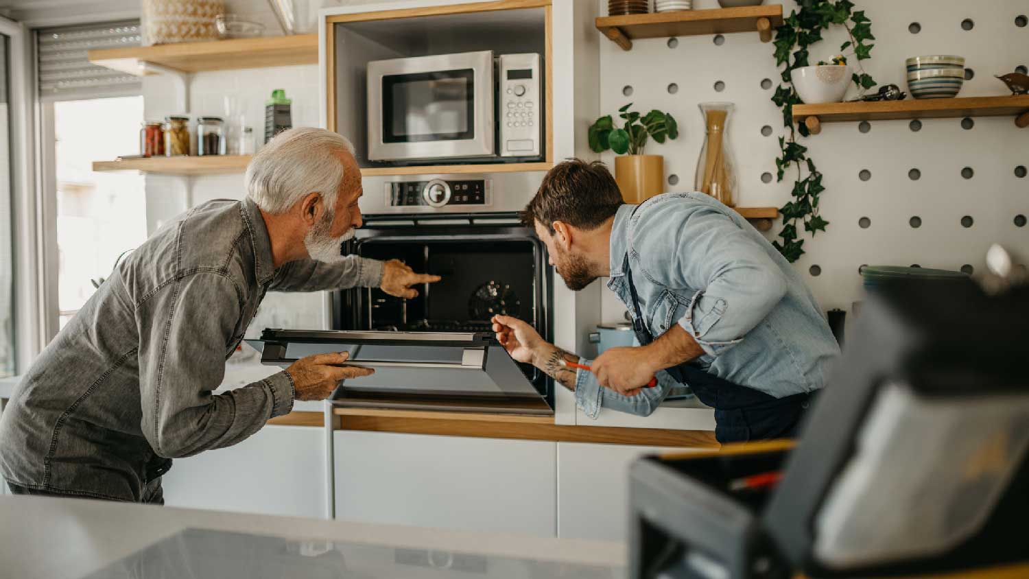 Two men inspecting an electric oven