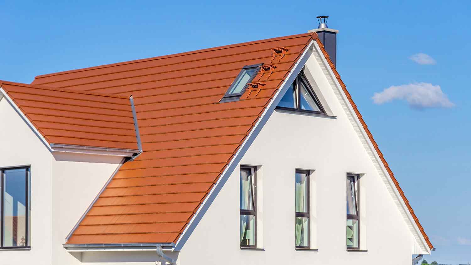 Red metal shingles installed on a sloped roof