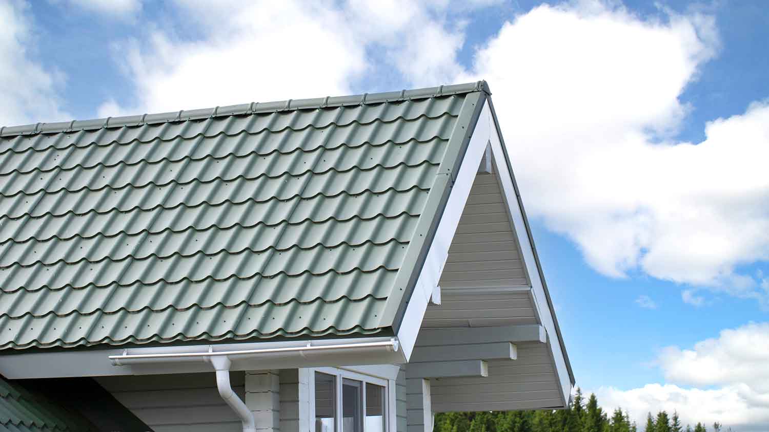 Green metal tiles installed on the roof of a house