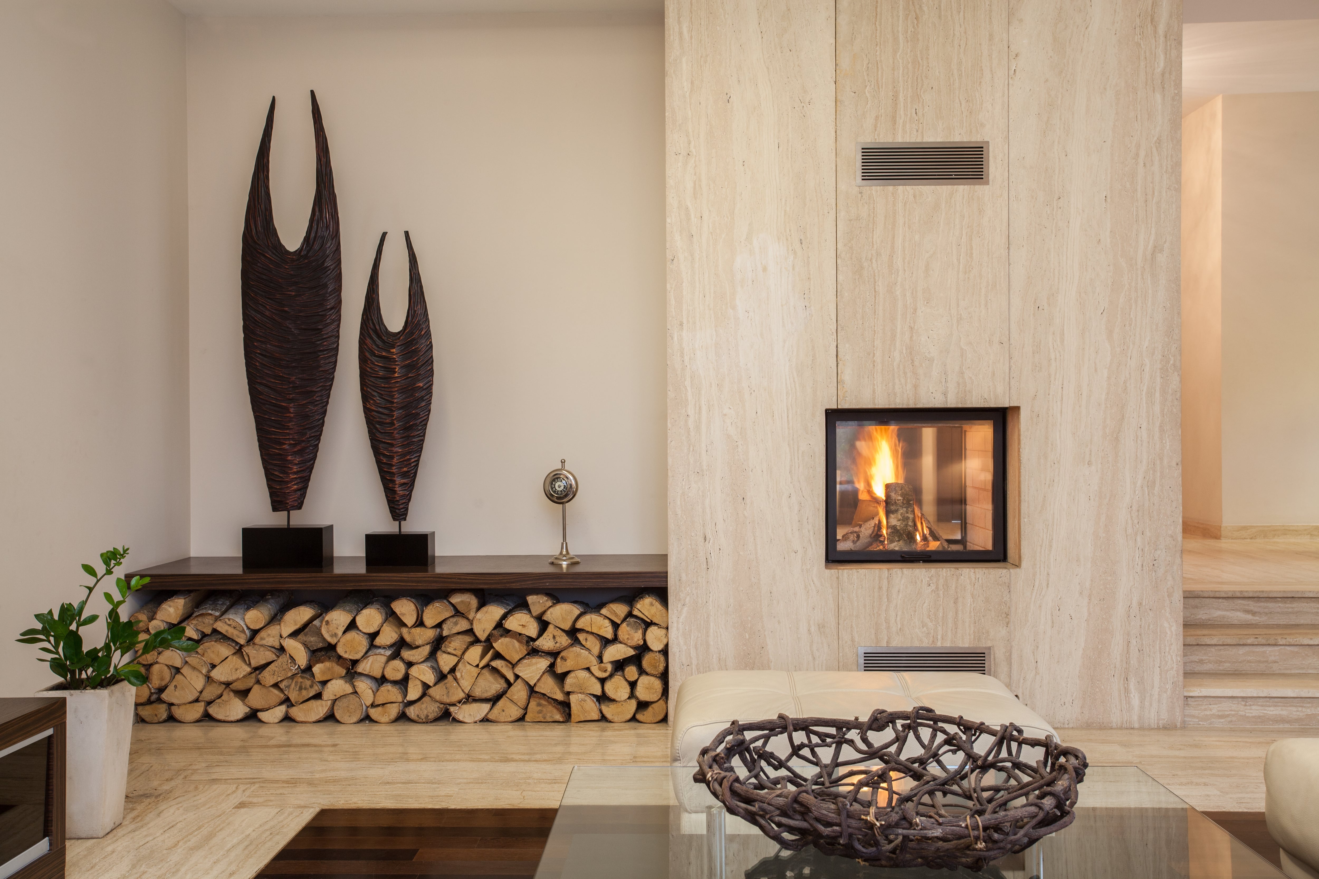 Modern living room featuring two large sculptures on a low shelf near a fireplace