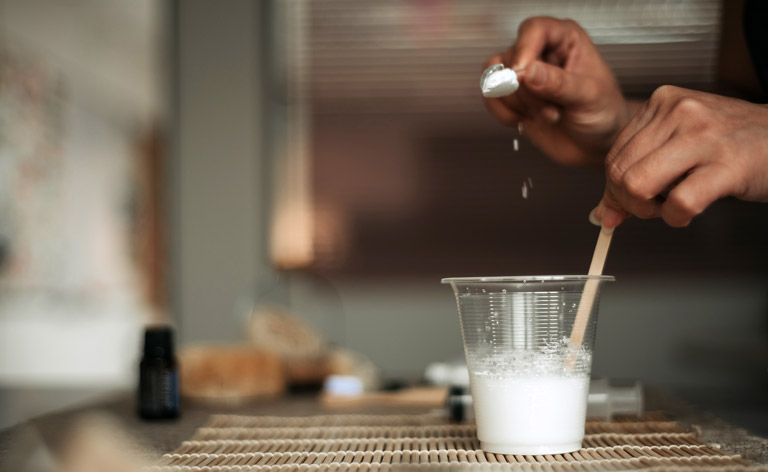 A woman’s hand mixing baking soda with water