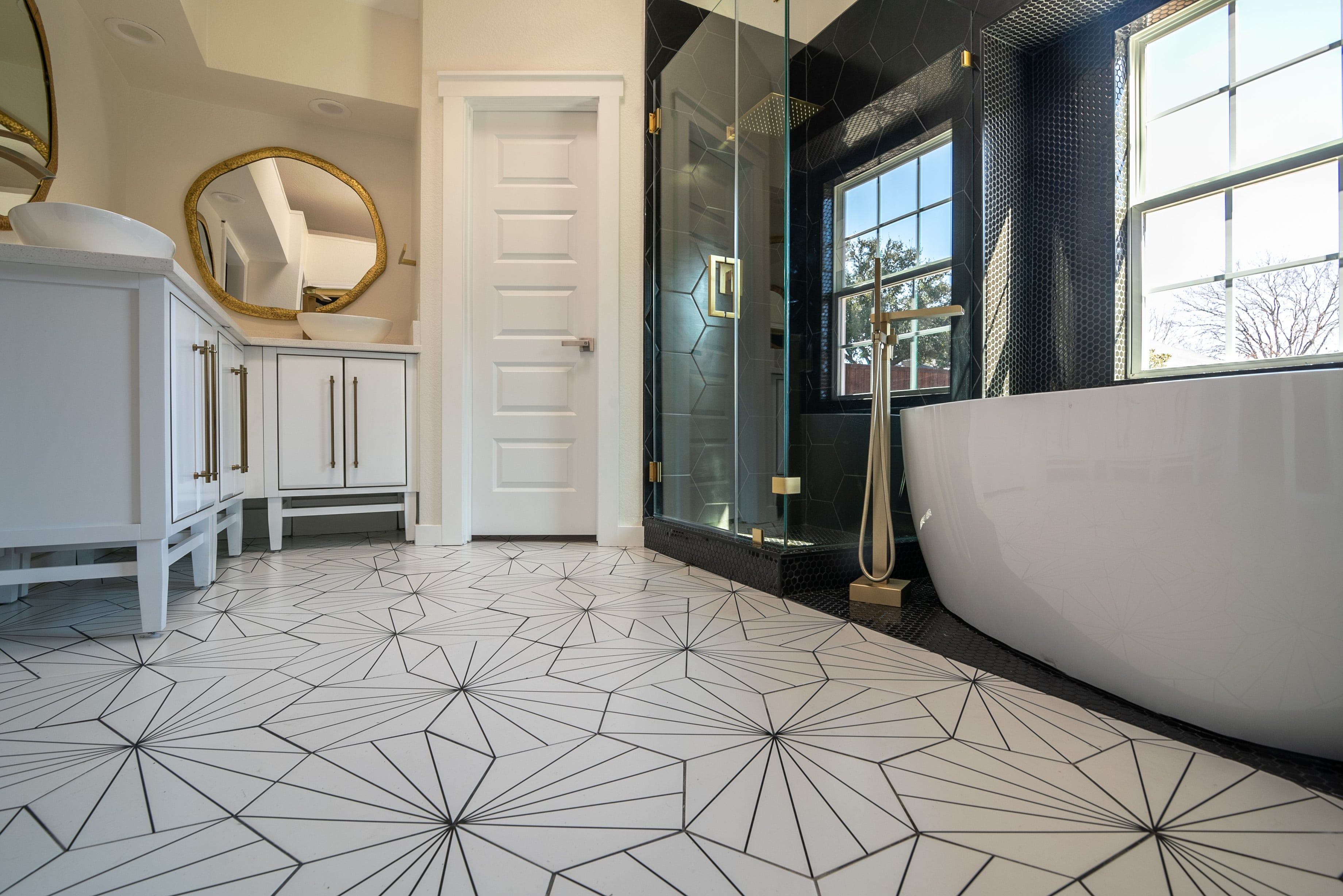 Luxurious bathroom with geometric-patterned tile and gold accents