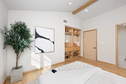 Modern bedroom with wooden baseboard and white walls