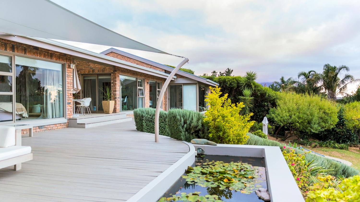 A modern house with a pond overlooking at nature