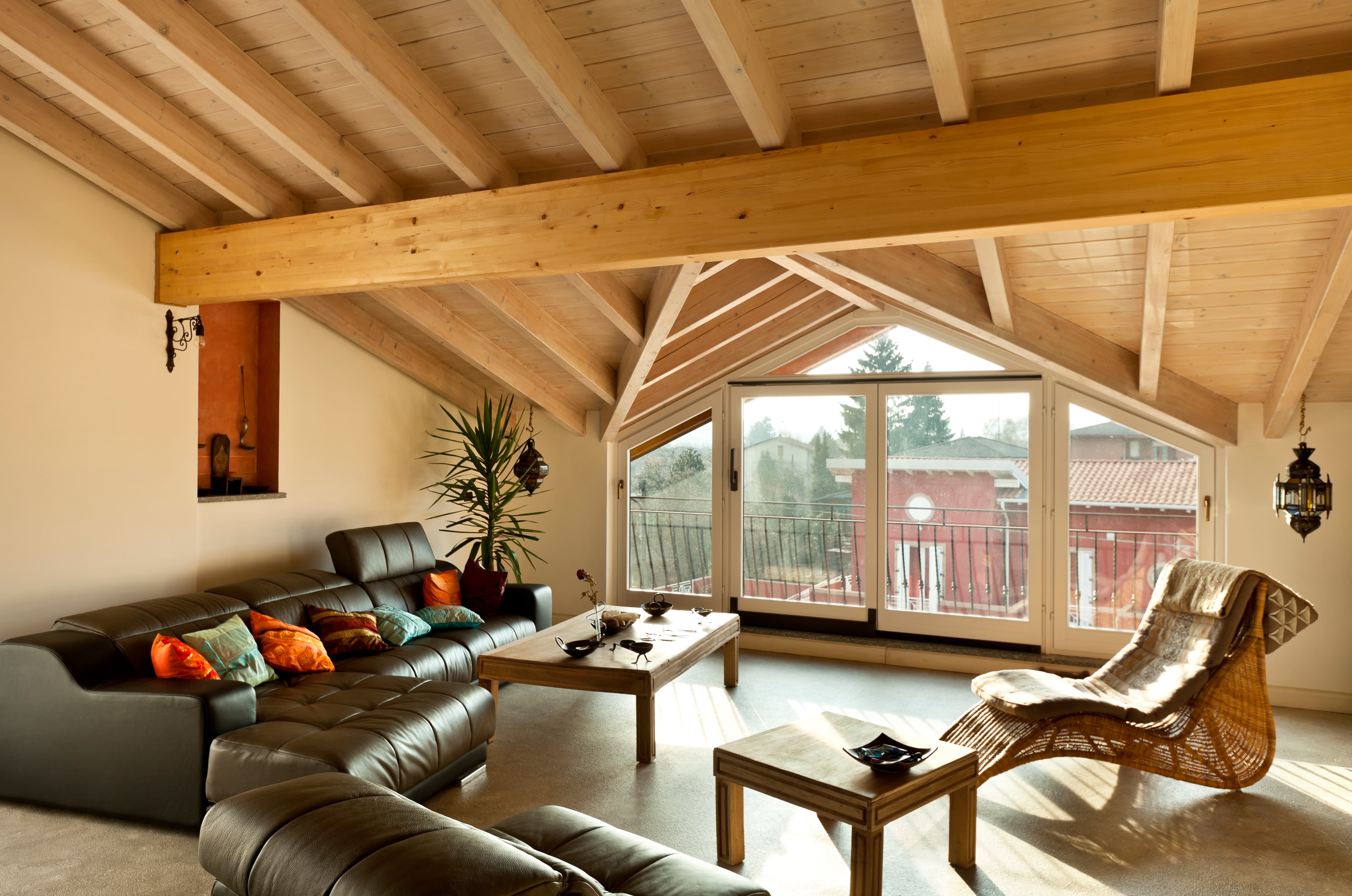 A lofted living room with an exposed wood beam ceiling and matching accents