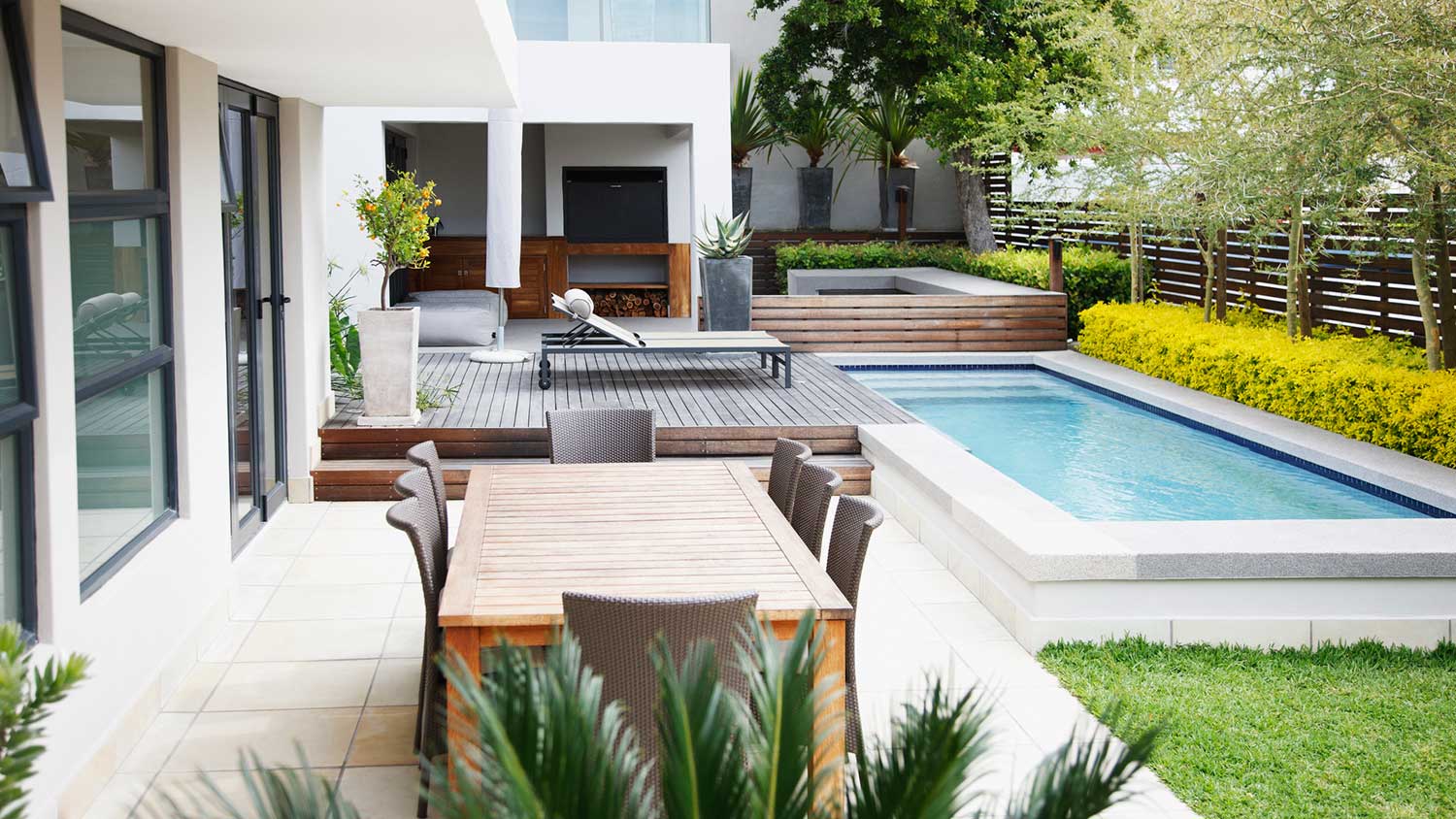 Modern patio with swimming pool and dining area