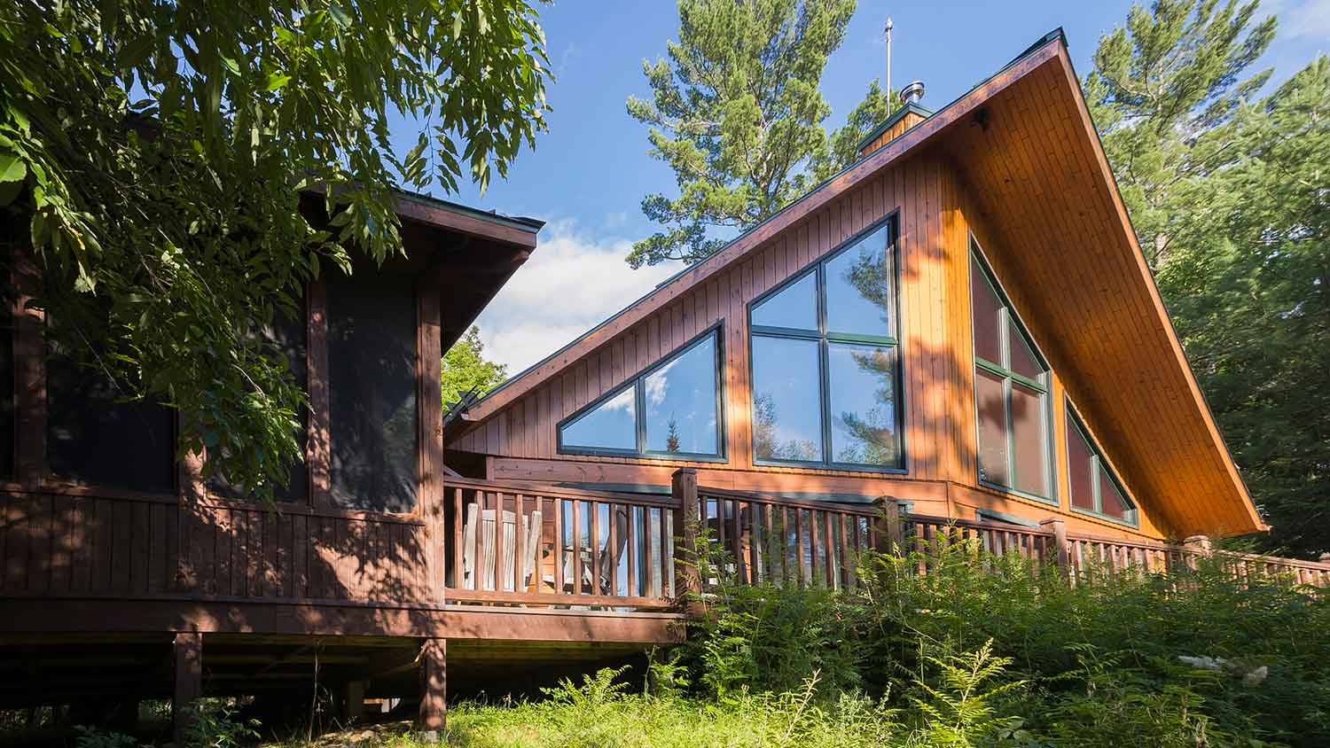 Modern wooden cabin with elevated deck and large windows