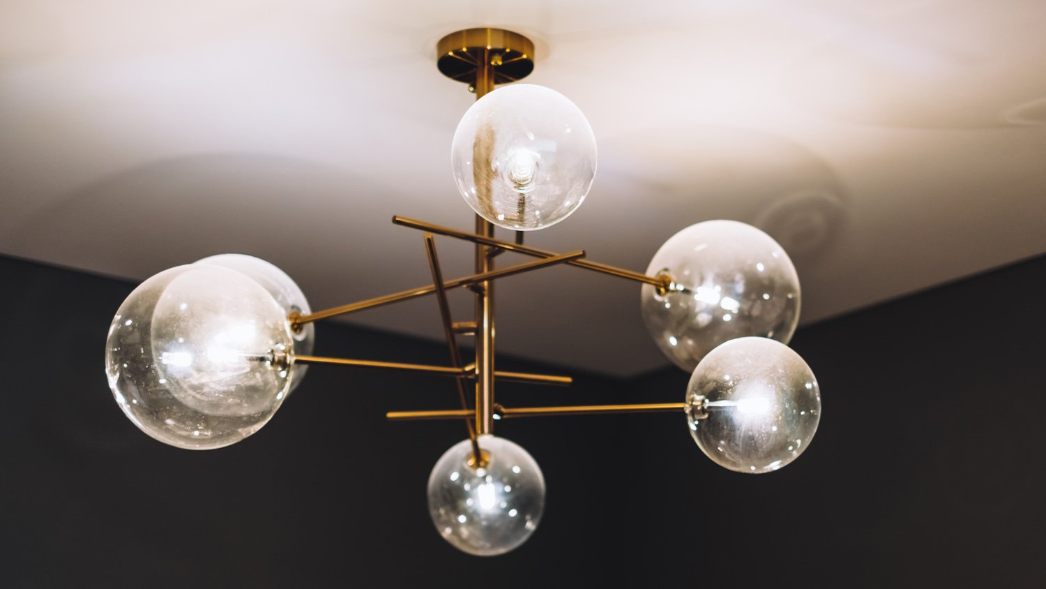 Glowing chandelier on the white ceiling