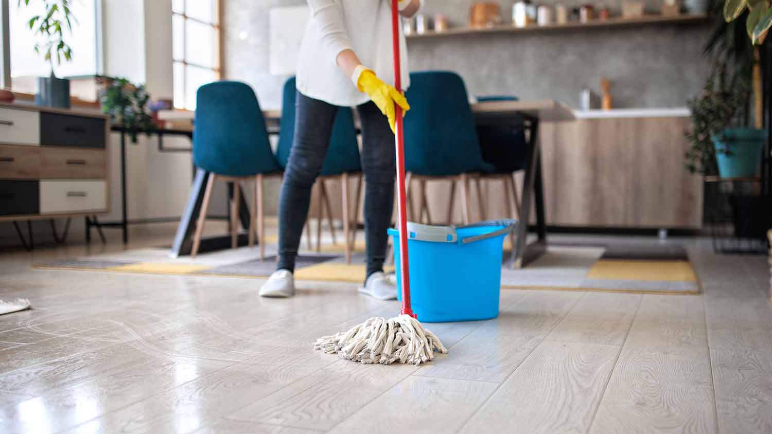 Woman using regular mop to clean the kitchen floor