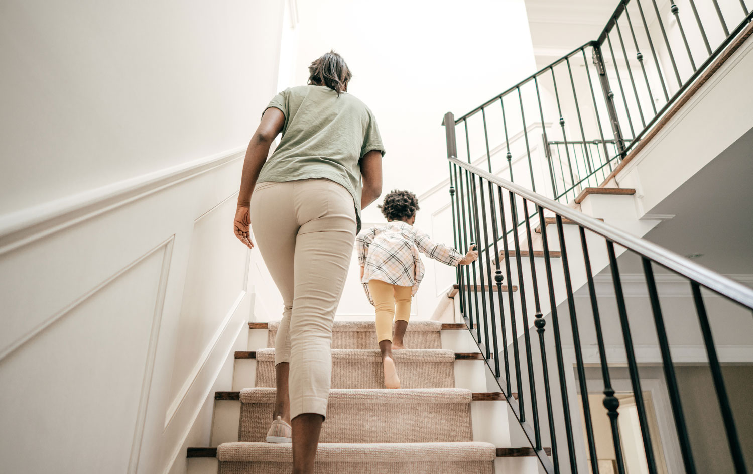 Mother and daughter going upstairs at home