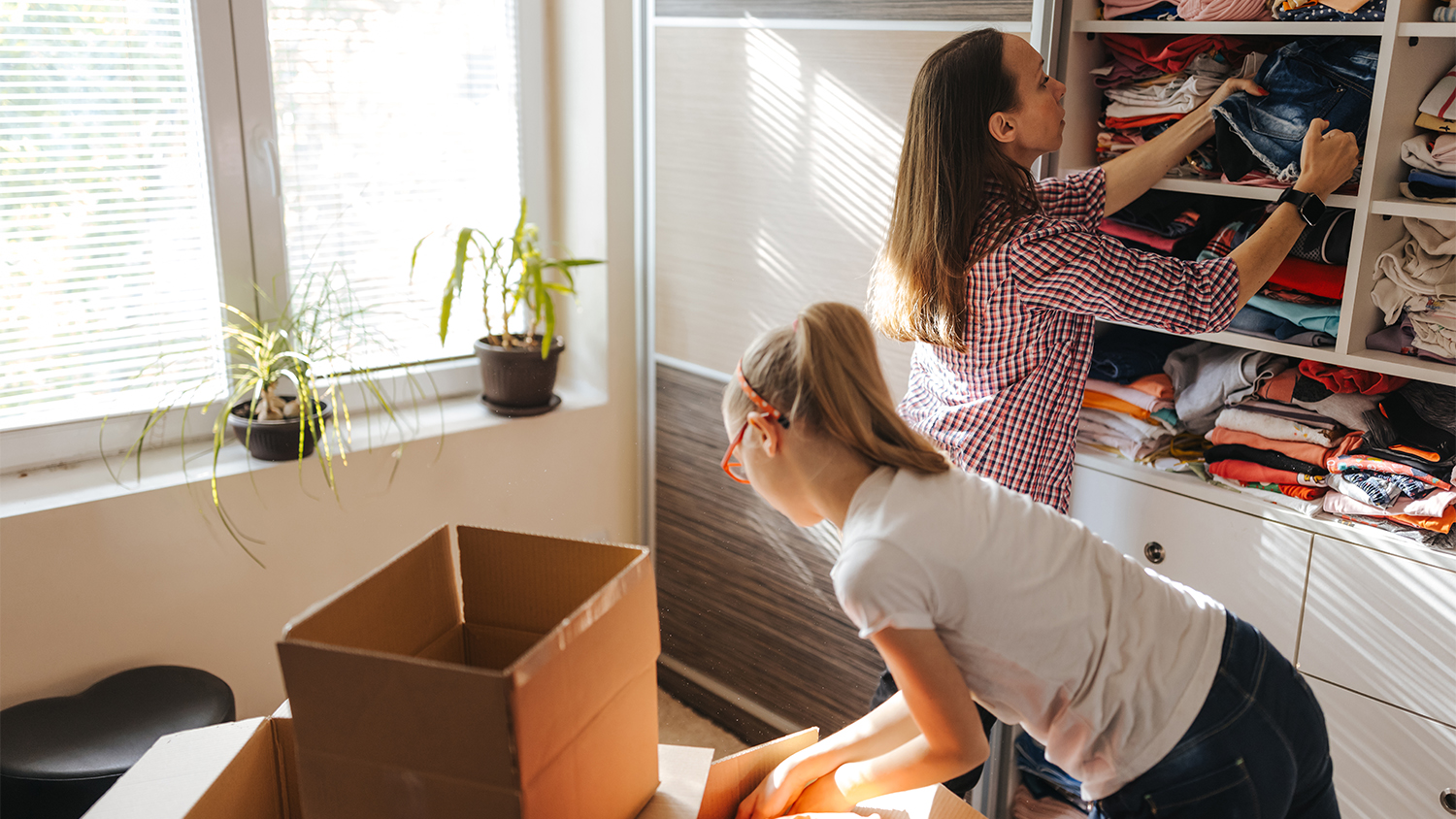 mother and daughter packing up clothes to donate