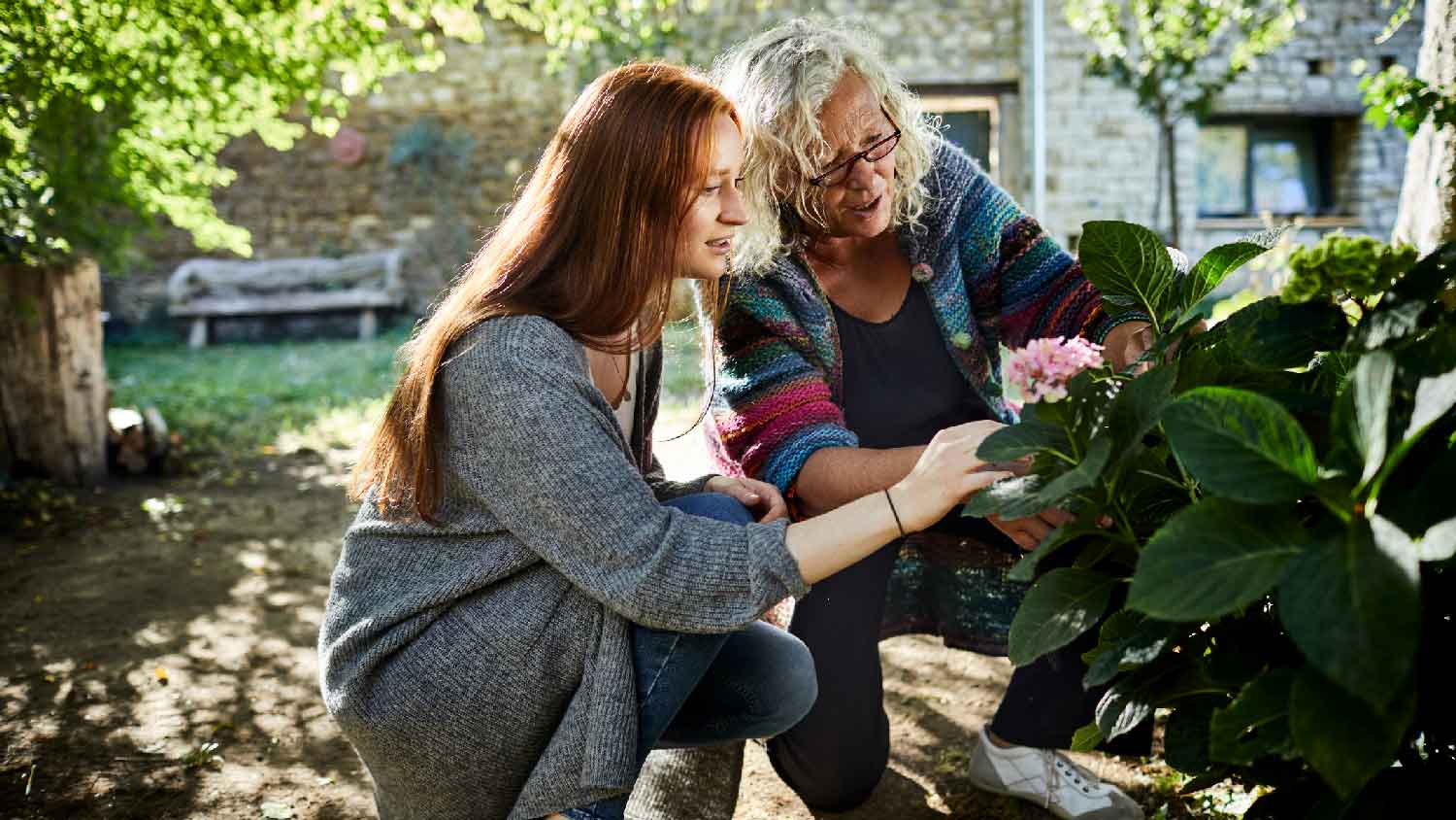 A mother and her daughter inspecting the garden plants