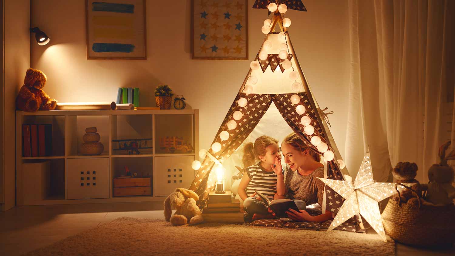 A mother reading a book to her daughter in the playroom