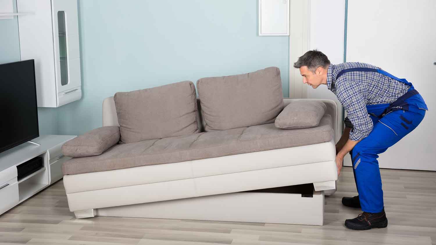 Professional mover lifting a loveseat sofa