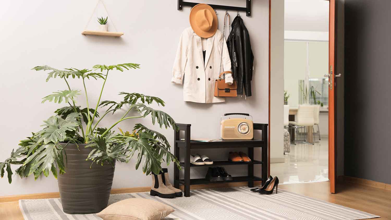 Mudroom with large potted plant and a coat rack