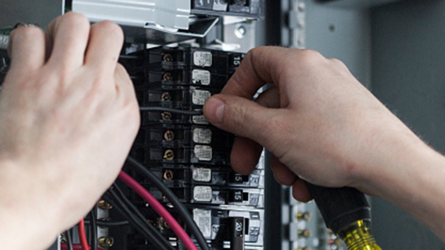 An electrician installing a new circuit breaker