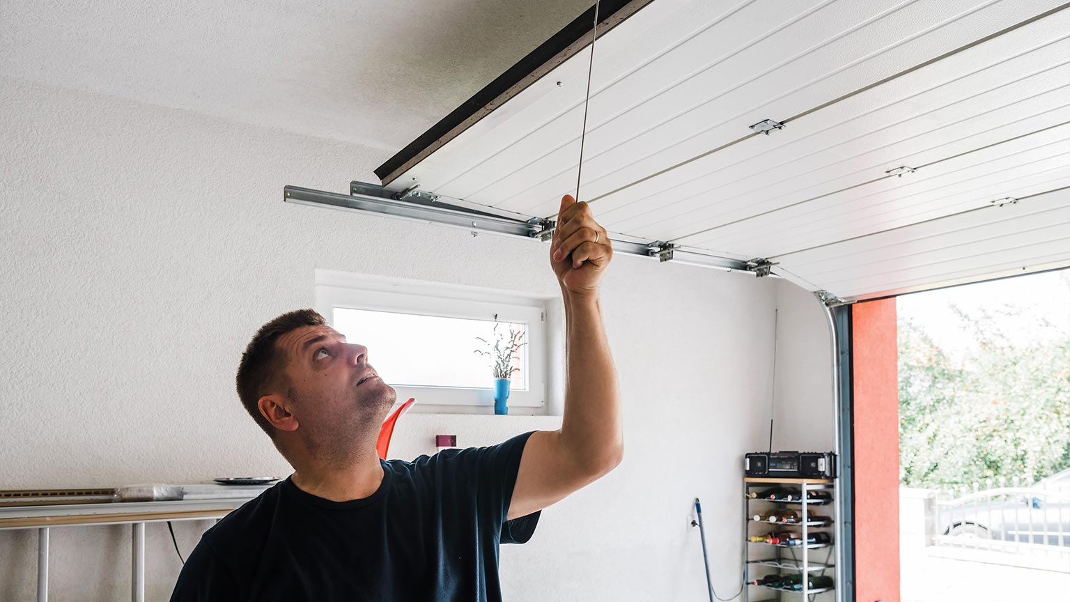 man opens pvc garage door manually